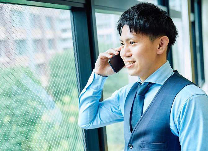 携帯電話で話をする笑顔の男性社員