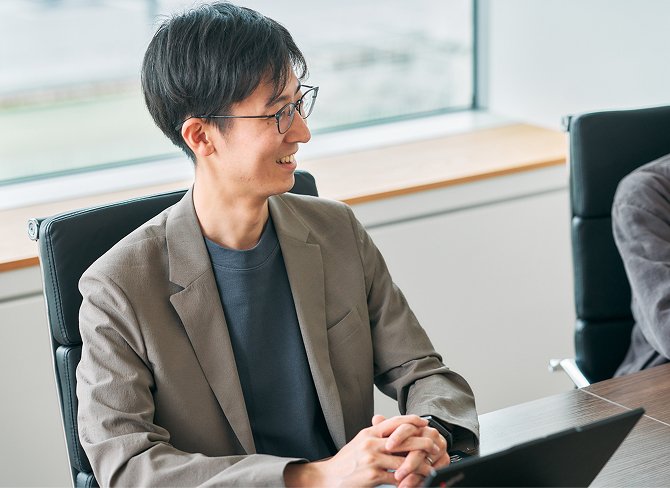 笑顔で打ち合わせを行う男性社員